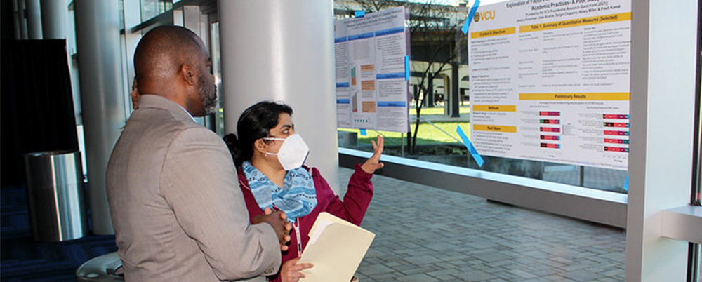 A participant in the Presidential Research Quest Fund explains their poster and work.