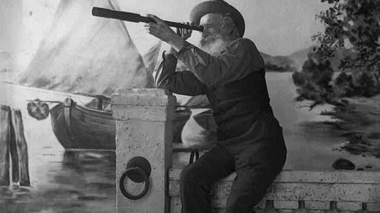 Black and white image of an old man using a spyglass in search of something. APA citation style: (ca. 1902) [Old man looking through spyglass]. , ca. 1902. [Photograph] Retrieved from the Library of Congress, https://www.loc.gov/item/2003675172/.
