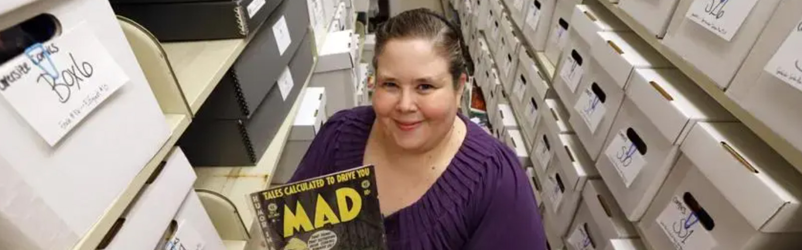 Cindy Jackson holding a MAD Magazine in the Comic Arts Collection at James Branch Cabell Library.