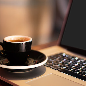 A cup of coffee sitting on a laptop