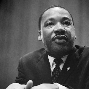 a black and white image of Martin Luther King, Jr. looking off to the side