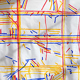 Closeup of a textile art piece consisting of a white sheet with colored lines drawn on it