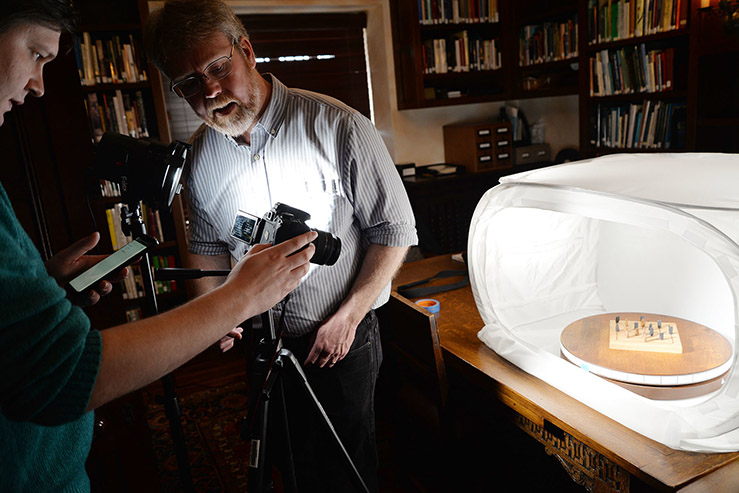 A photo of Joshua Dow and Eric Johnson photographing an item from Agecroft Hall.