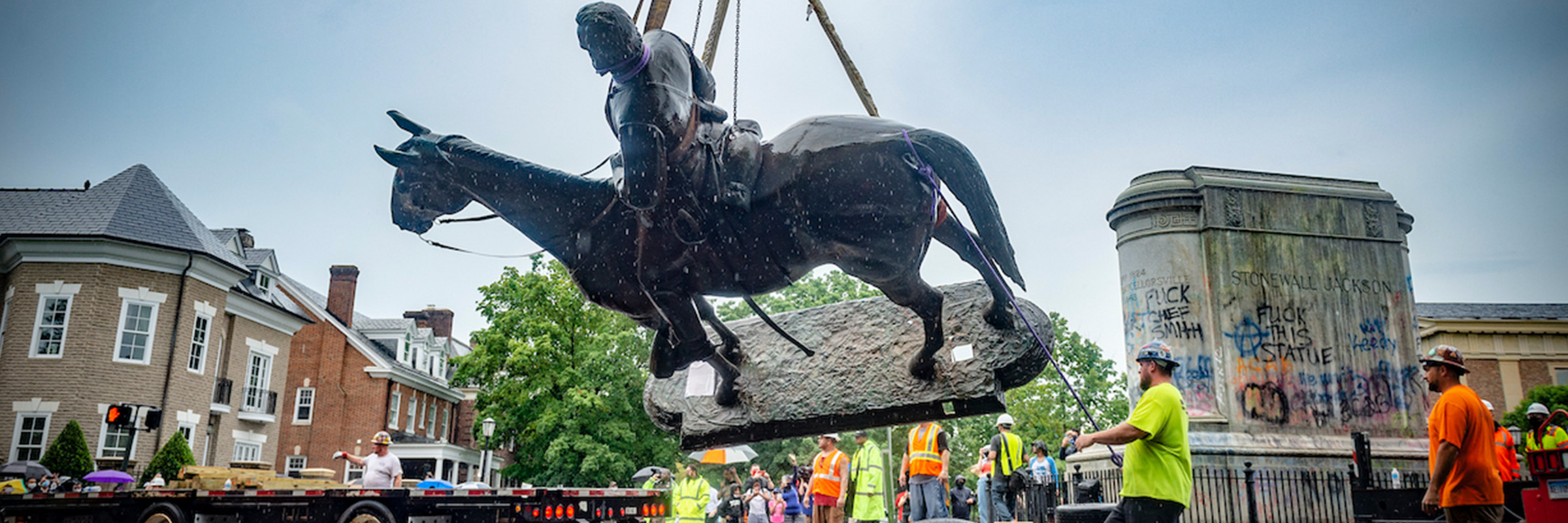 The Robert E. Lee statue being removed from Monument Ave. surrounded by construction workers with a truck.