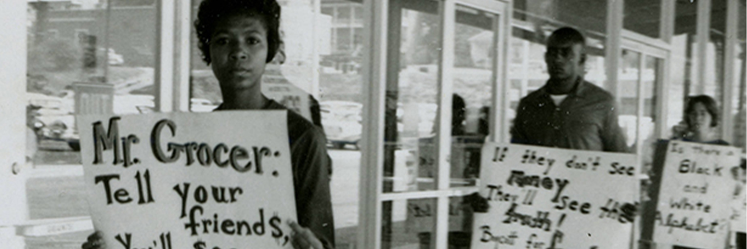 Protesters at Grants, Farmville Shopping Center, August 1963. Students carry signs opposing racial segregation, and encouraging shoppers to boycott businesses that support discriminatory practices.