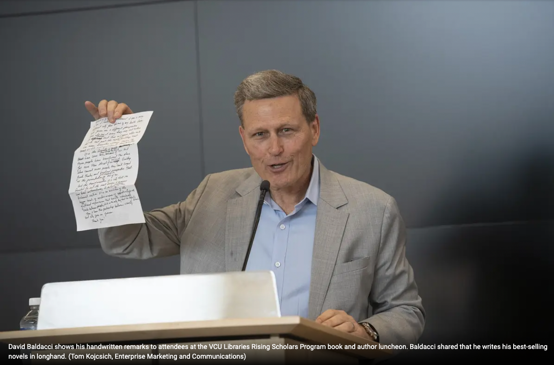 David Baldacci shows his handwritten remarks to attendees at the VCU Libraries Rising Scholars Program book and author luncheon. Baldacci shared that he writes his best-selling novels in longhand.